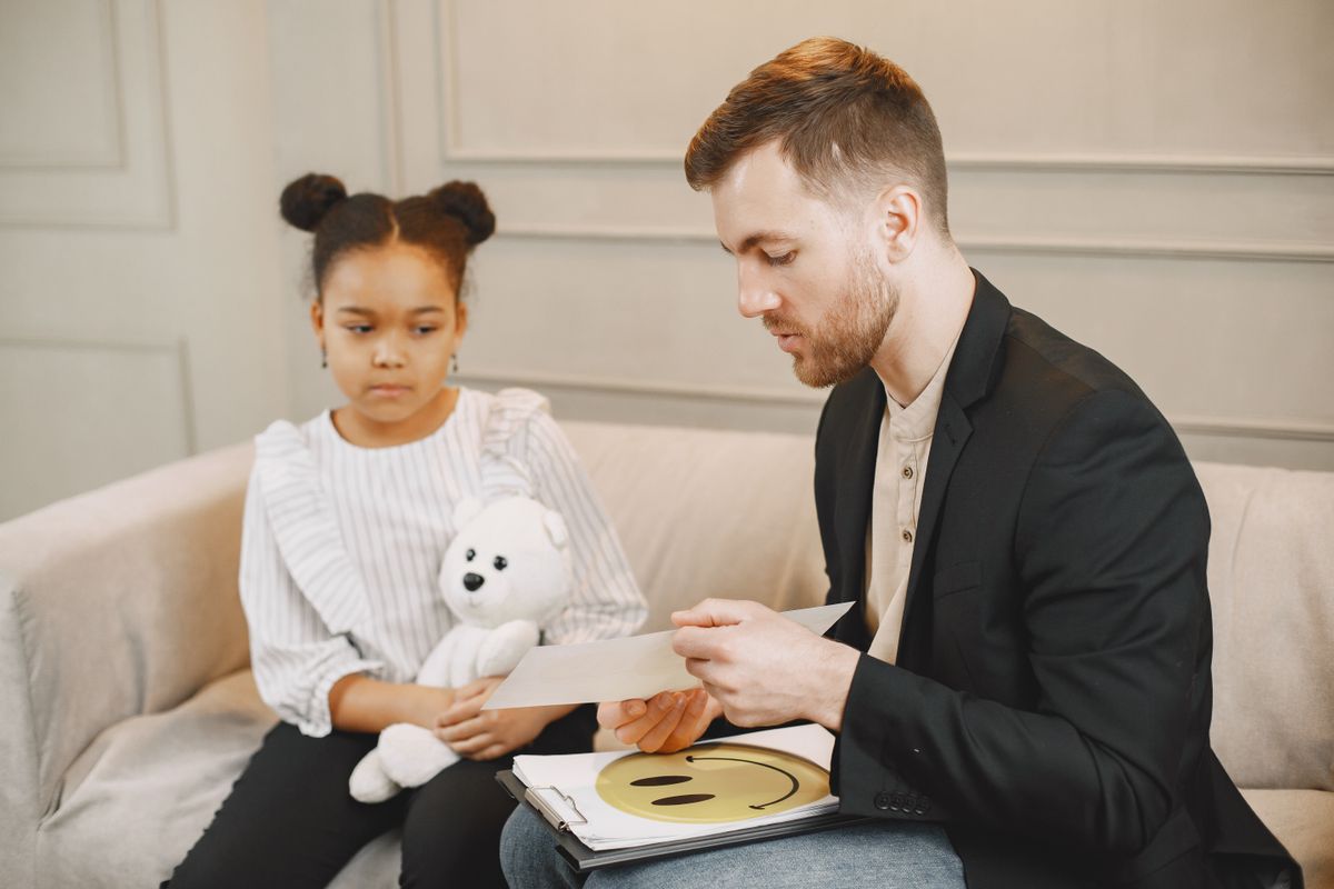 Psychologue échangeant avec un enfant dans un cabinet lumineux