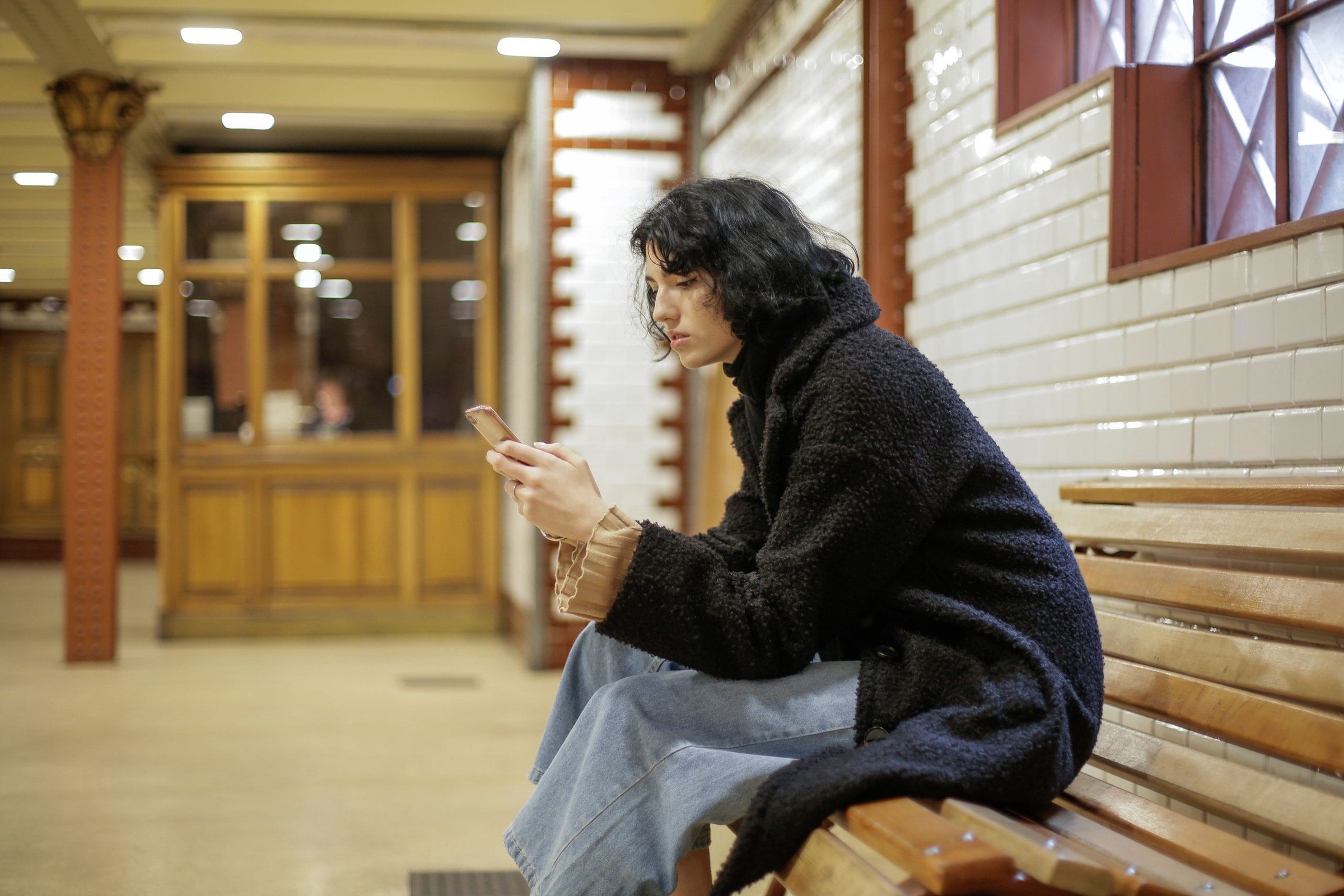 Femme lisant un SMS sur son téléphone en se demandant pourquoi il ne propose pas de se voir